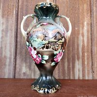 Front view showing painted landscape scene, pink rose garland on lower body, gold gilt trim.