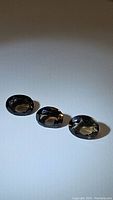 Three oval cut natural smokey quartz gemstones arranged in a line, showing their color and clarity under natural light.