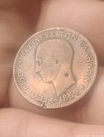 Obverse of the copper coin showing the profile of King George I of Greece and the year 1869.