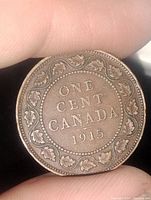 Close-up of the reverse side of the 1915 Canadian one cent large cent coin showing denomination and maple leaf wreath.
