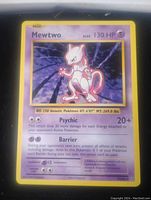 Photo showing a close-up of the Mewtwo Pokemon card with visible text, artwork, and stats.