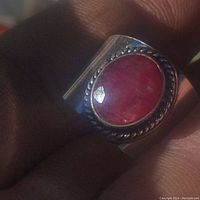 Close-up image showing the large oval cut ruby set in silver plated band with twisted rope setting detail.