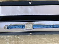 Full view of Blue Dolphin wrist watch with blue band in original black box with satin lining.