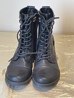 Front view of a pair of black army style lace-up boots showing toe and laces
