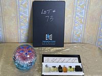 Black box with handwritten lot number and logo, showing all items arranged on a surface