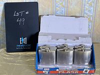 Box containing six identical stainless steel flasks, arranged in two rows of three, showing the full set and packaging.
