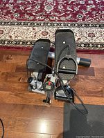 Top-down view of Bally hydraulic stepper showing foot pedals, cables, and monitor on wood floor.