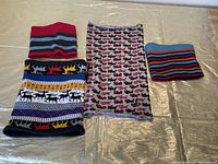 Overview of four winter neck warmers in varying sizes and colorful patterns laid out on a surface.