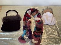 Set of scarf, handbag, and touque laid out on a flat surface.
