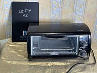 Black and Decker toaster oven side view showing front glass door, control dials, and power cord