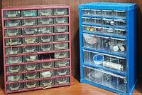 Front view of both red and blue hardware caddies filled with various small parts