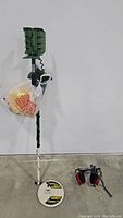 Full view of metal detector with coil and shaft, deep target tool attached, and headphones placed beside it.