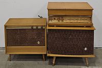 Overall view of stereo console with floor speakers showing front and side views, blond wood finish, fabric speaker grilles, control knobs, and Silvertone badges