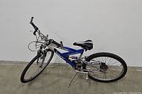 Side angle showing full view of blue NEXT Breakpoint PRO bicycle with aluminum frame and suspension components.