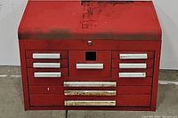 Front view of red 10-drawer tool chest with various labeled drawers and a central lock.