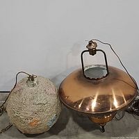 Photo showing both the spun spaghetti swag lamp and the copper ceiling pendant light on the floor against the wall.