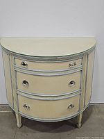 Front view of the half-moon shaped Italian wooden chest with three drawers and metal ring handles.