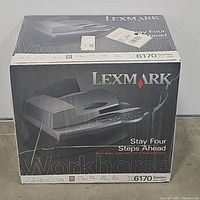 Front and top view of the unopened box of the Lexmark Workhorse X6170 Series All-In-One Printer showing branding, product image, and key features.