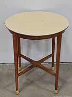 Front view of round table showing top and four legs with X-brace stretcher