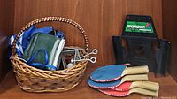 Full lot showing wicker basket with nets, hooks, three paddles, and Sportcraft paddle holder