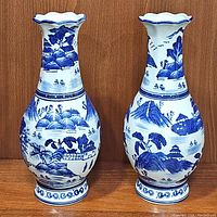 Pair of Asian blue and white porcelain vases showing full front views and design details.