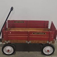 Red wooden Radio Flyer Town & Country wagon showing metal hardware, white wheels, and black metal handle.