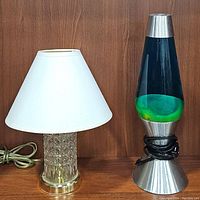 Both lamps side by side: crystal table lamp on left, black and green lava lamp with silver base on right