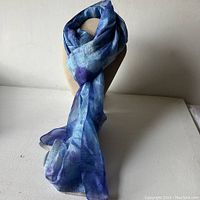 Photo showing the full length of the cobalt blue silk scarf draped on a mannequin, displaying its color and texture.