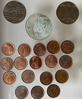 Display of Canadian coins including two Confederation pennies, several pennies of various years including 2003, 2004, and two 2007 coins, and a large 1976 Montreal Olympics 5 Dollar coin.