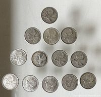 14 Canadian Silver Quarter Coins arranged in a triangular formation, showing the caribou reverse side with visible wear and toning.