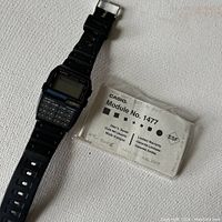 Front angle of Casio Data Bank 150 wristwatch with calculator and accompanying user manual.