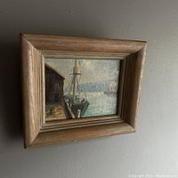 Framed oil painting showing dock and boat scene with muted natural colors, signed by F.M Sargent.