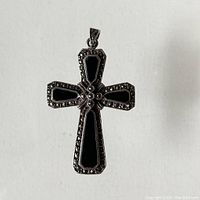 Front view of the sterling silver marquisette onyx cross pendant showing black onyx inlays and marcasite detailing around edges.