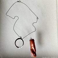 Full view of necklace chain with two pendants on a white background.