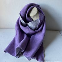 Full view of the Club Monaco knit scarf draped on a stand showing its purple color with some light gray revealed inside folds.