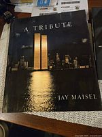 Photo of the large photo book titled 'A Tribute' by Jay Maisel showing the Twin Towers at night on the cover