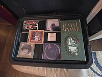 Overview of CDs including Lynyrd Skynyrd Definitive Collection 3 Set, U2, Bob Dylan, and John Mellencamp CDs in a black case.