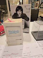 1983 Macintosh-themed paper cube and the Steve Jobs book by Walter Isaacson displayed side by side
