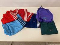 Full display of four Adidas pants and two shorts (Nike and Asics)