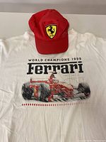 White Ferrari branded XL T-shirt with 1999 World Champions print featuring a red F1 racing car, displaying some stains.