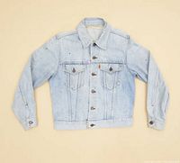 Front view of vintage Levi's Type III denim jacket in light wash blue, showing classic chest flap pockets, buttons, and overall wear including paint splatter.