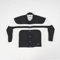 Full front view of the vintage Nike track jacket showing black and white color blocking and snap dome buttons.