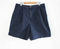 Front view of navy Tommy Hilfiger chino shorts showing pleats and button fly closure