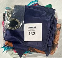 Lot of layered silk scarves with a navy blue scarf on top along with a pin/brooch in plastic bag.