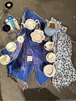 Overall lot including all items arranged on the floor with two wraps, cups and saucers, vase, candle holders, teapot, jug and bowl