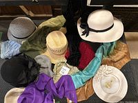 Group photo showing 10 hats of various styles including formal, sun, beret, and toque styles alongside scarves in different colors and textures.