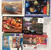 Photo showing six different jigsaw puzzle boxes arranged in two rows, highlighting the variety of puzzle themes and piece counts.