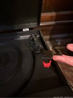 Close-up of Sharp record player cartridge and stylus on tonearm