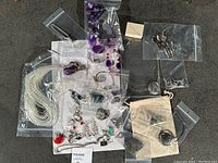 Overall lot contents including necklaces, earrings, rings, pendants, brooches, scarves, barrettes and packaging.