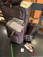 Full view of the luggage and assorted travel accessories arranged on a bench.